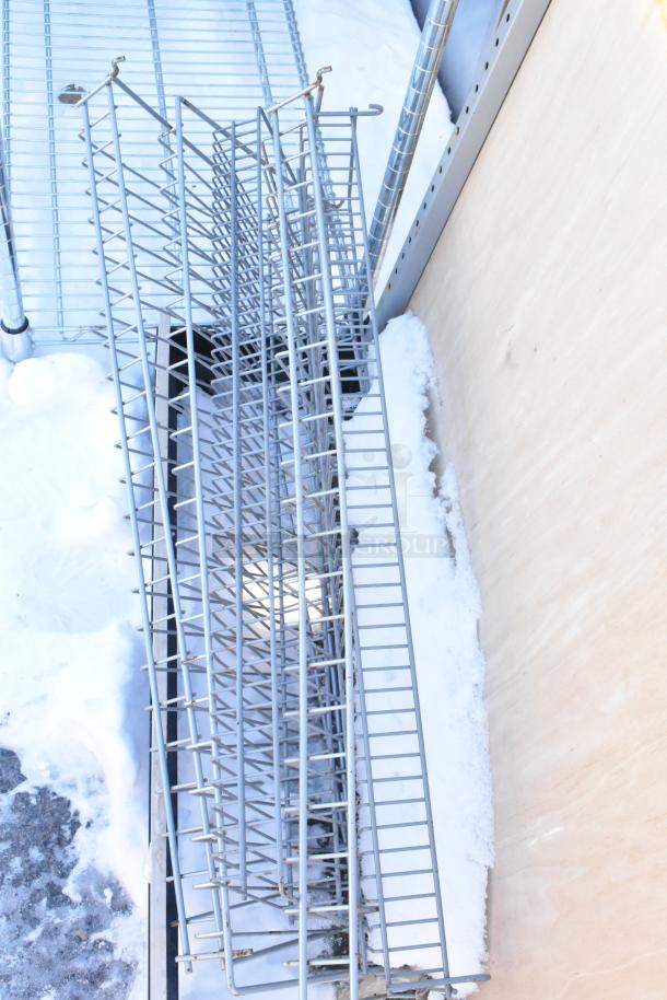 Metal display rack with wire shelves, used condition, visible snow and outdoor setting.
