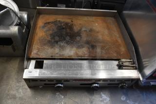 American Range commercial countertop flat top griddle with thermostatic controls, showing wear on cooking surface.