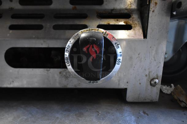 American Range commercial countertop flat top griddle dial, showing temperature settings. Signs of use visible.