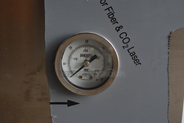 Stainless steel gauge of Noble 495HTGW22 dishwasher, showing PSI and kPa measurements. Marked "WEISS" with NSF certification.