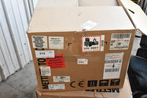 Cardboard box labeled for Mettler Toledo, showing various shipping and handling labels, including Walmart PO and UN 3091.