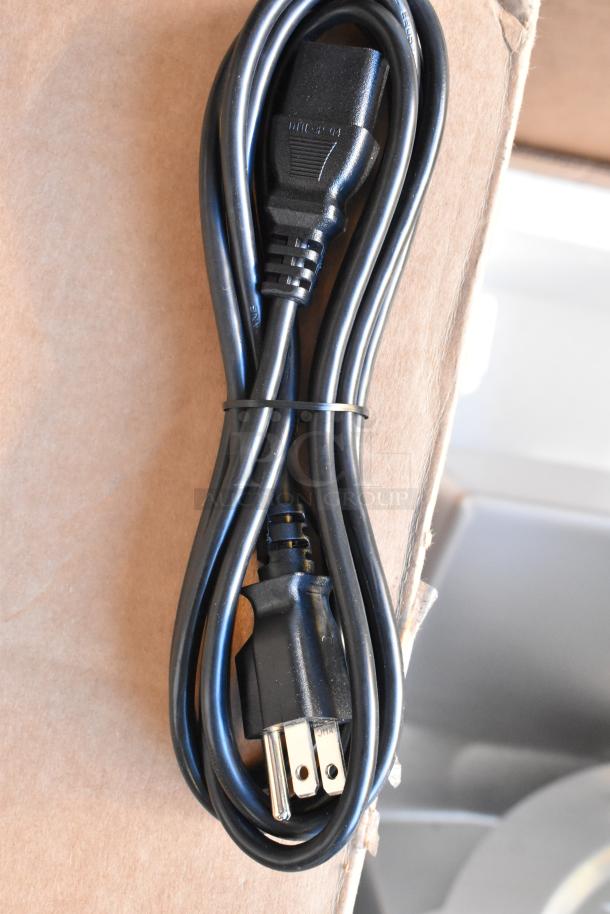 Black power cord for Mettler Toledo FreshWay Scale, neatly coiled, resting on a cardboard surface.