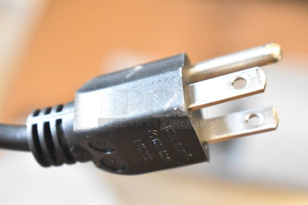 Plug of Mettler Toledo AM-5545 scale, showing three-prong design and visible model information.