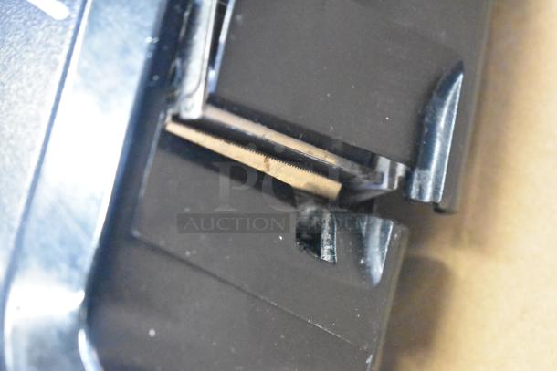 Close-up view of a component of the Hobart HTi-7LH26 food portioning scale, showing metal and plastic parts.