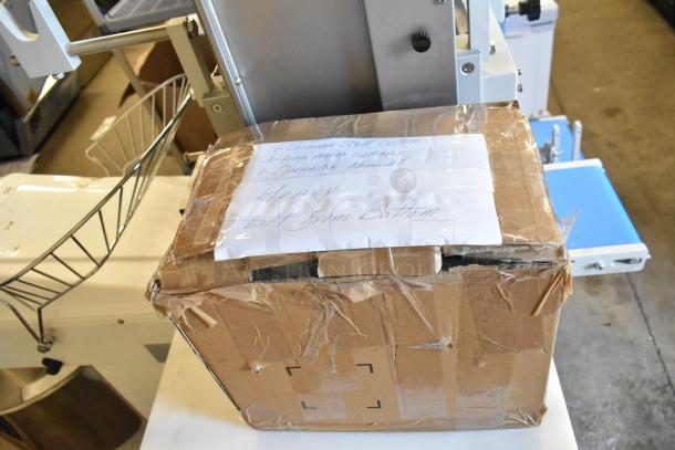 Arcobaleno AMF160 commercial pasta machine on casters, shown with accessories in a cardboard box, labeled "Heavy, Lift From Bottom."