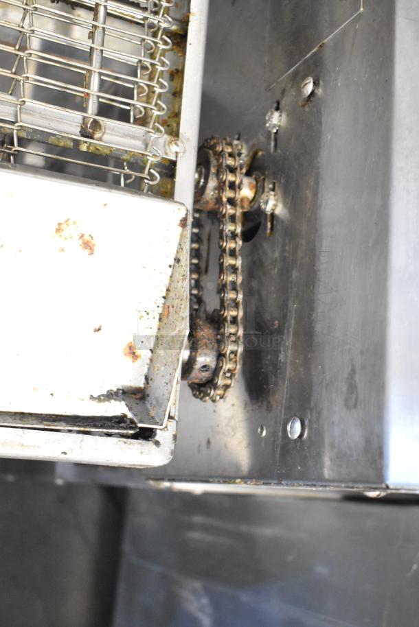 Close-up of Middleby Marshall PS638G pizza oven chain mechanism, showing stainless steel construction and signs of wear.