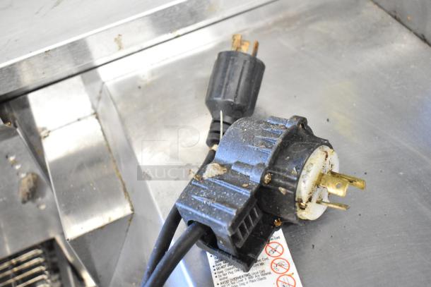 Close-up of power plug on stainless steel surface, showing signs of use on a Middleby Marshall commercial pizza oven.