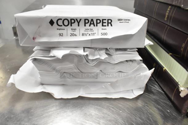 Lot of approximately 25 items includes notebooks, reams of 92 brightness copy paper, and a Lexmark printer cartridge.