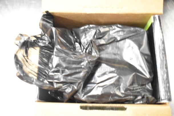 Box containing approximately 25 office items including notebooks, copy paper reams, and a Lexmark printer cartridge.