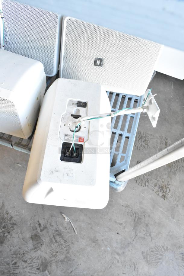 Six JBL Control 28-1-WH 8 Ohm speakers, white, show some wear. Features include robust design and versatile mounting options.