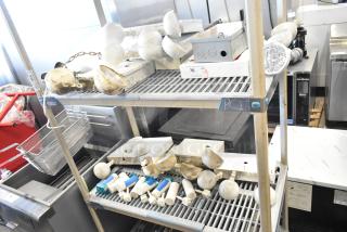 Auction items: emergency lights, exit sign, Eaton power box, assorted on shelves. Condition varies, some items worn.