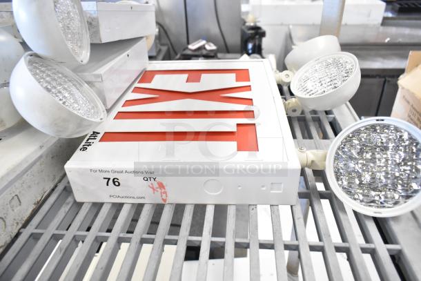 19 assorted items including emergency lights, an Exit sign, and an Eaton power box, in used condition.