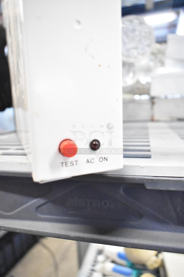 Various electrical items including emergency lights and Eaton power box, featuring a unit with test and AC on indicators.