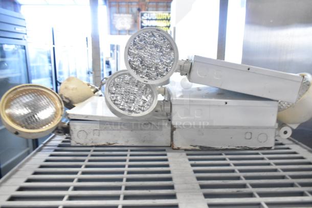 19 mixed items including emergency lights, exit sign, and Eaton power box; used condition, see image for details.