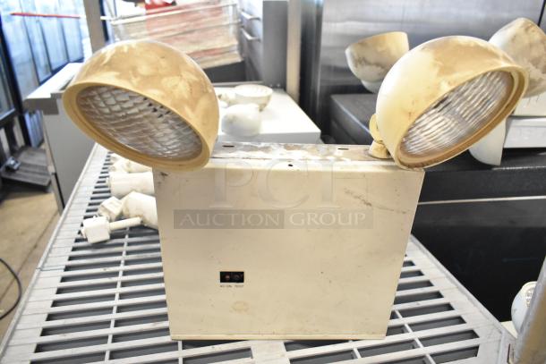 Emergency lights with dual adjustable lamps, AC ON and TEST indicators, in used condition. Part of 19-item auction.
