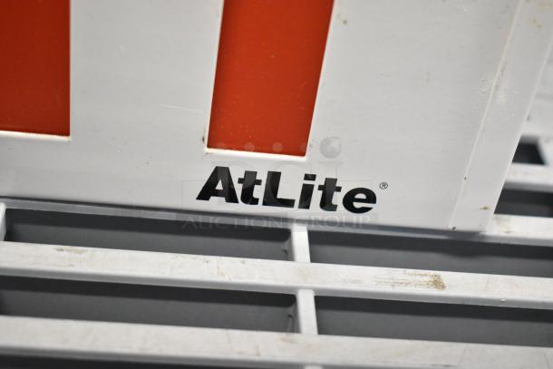 AtLite branded exit sign in used condition, part of a lot with emergency lights and Eaton power box.