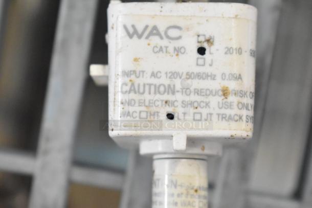 Close-up of a WAC electrical component, marked with caution for risk of electric shock, AC 120V, 50/60Hz, 0.09A. Condition shows wear.