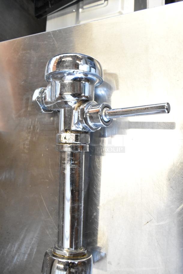 Chrome toilet flushing handle in excellent condition. Features polished finish, sturdy lever mechanism. Text indicates "Sloan Valve Co."