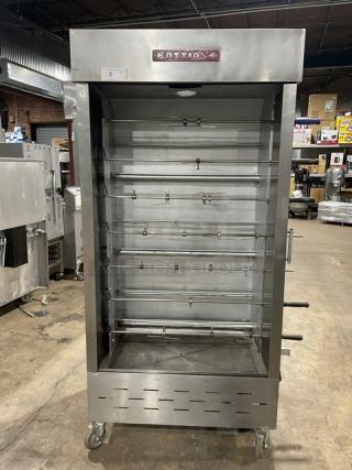 Attias commercial stainless steel full-height rotisserie cabinet on casters, gas-powered, featuring multiple skewers.