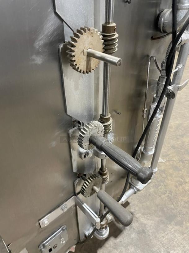 Attias commercial stainless steel gas rotisserie cabinet, full-height, on casters. Visible gears and handles, in used condition.