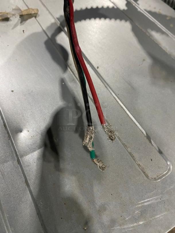 Black, red, and green electrical wires with exposed ends, placed on a metal surface. Condition appears used.