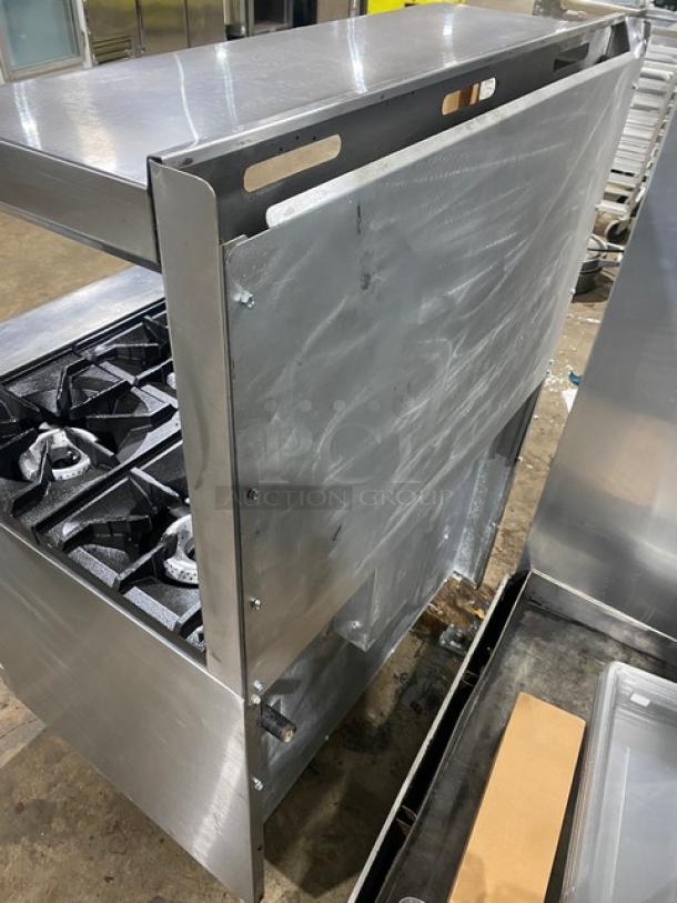 American Range stainless steel gas-powered 6-burner oven combo with backsplash, overhead salamander shelf, wired oven rack, and legs.