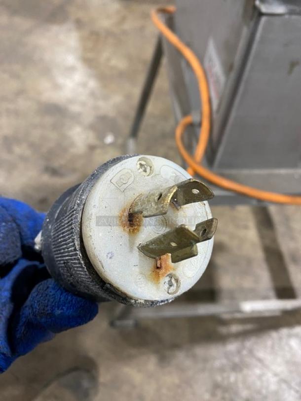 Jaccard E93 meat tenderizer plug, showing wear and rust on metal prongs; industrial-grade, electric powered.