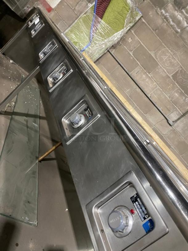 Wells stainless steel 8-well hot food steamtable, electric powered, with individual controls and undershelf, on legs.