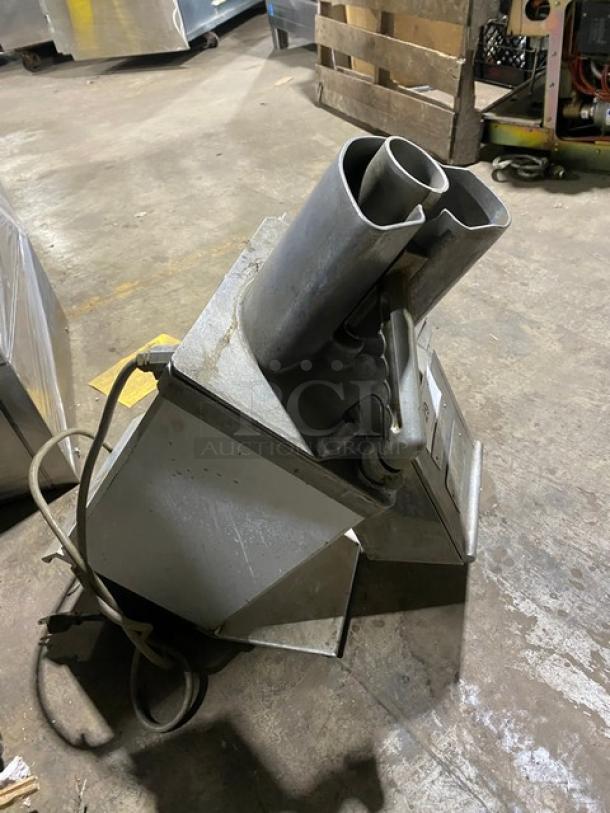 Hobart commercial electric-powered countertop continuous feed food processor, showing angled metal body, dual feed chutes, and attached power cord.