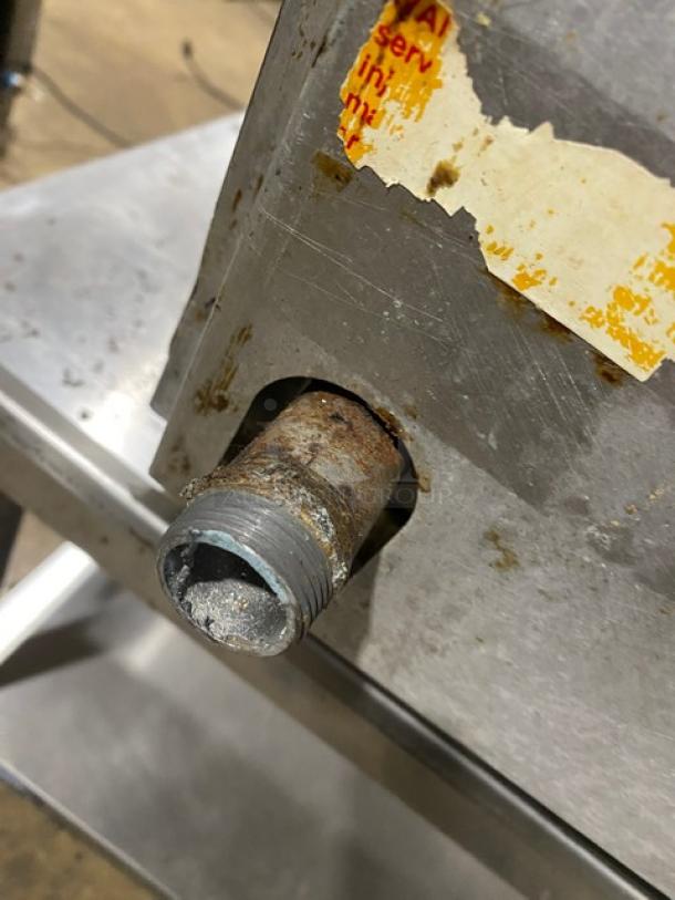 Rankin-Delux GT-36-C griddle, natural gas powered, stainless steel, with rusted connector and worn label, on legs.