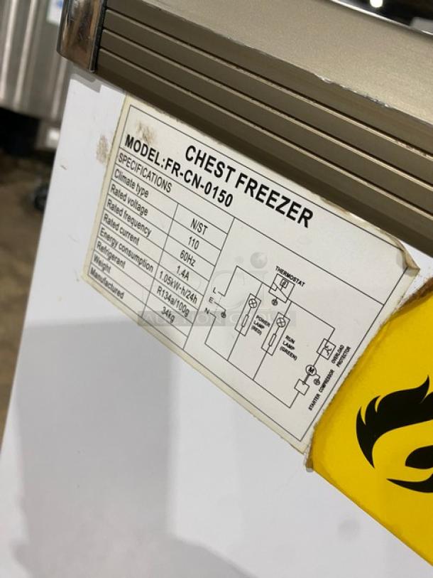 Omcan commercial merchandiser freezer, model FR-CN-0150, with double glass sliding lid, 110V, label showing specifications.