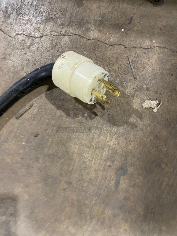 Close-up of an industrial power plug for the Bunn ThermoFresh DBC Dual Coffee Brewer, showing three brass prongs and white casing.