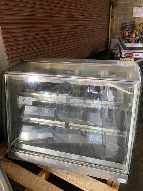 Vendo stainless steel slanted glass hot food merchandiser with 115V electric power, sliding rear doors, fair condition.