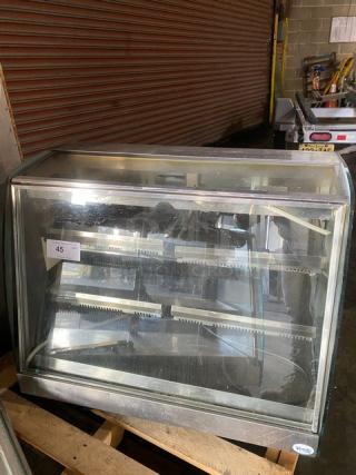 Vendo stainless steel slanted glass hot food merchandiser with 115V electric power, sliding rear doors, fair condition.