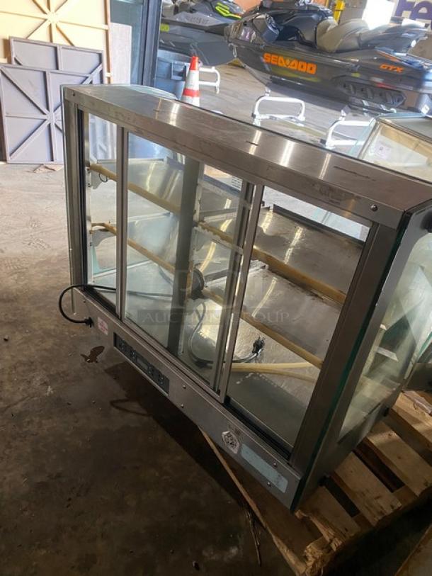 Vendo stainless steel heated food merchandiser with slanted glass, three tiers, and rear sliding doors. 115V, 1 Phase.