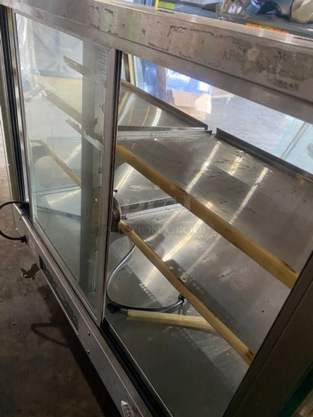 Vendo stainless steel countertop heated food merchandiser with slanted glass, multi-tier shelves, rear sliding doors, 115V, used condition.