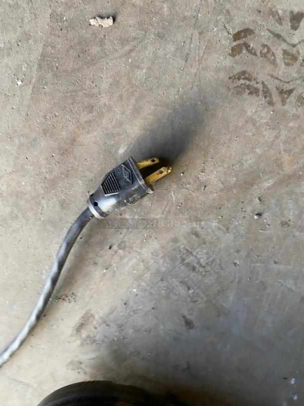 Plug of Nemco 8075SX-208-SP hot dog roller grill, showing standard 208V plug type, on a concrete floor.