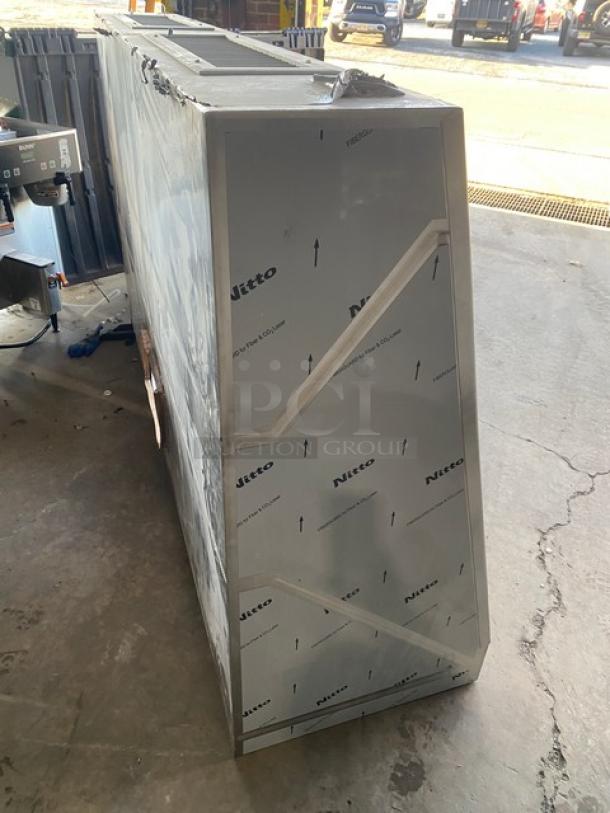 Commercial stainless steel kitchen exhaust hood, brand new with protective film, label indicates "Nitto". Ideal for professional use.