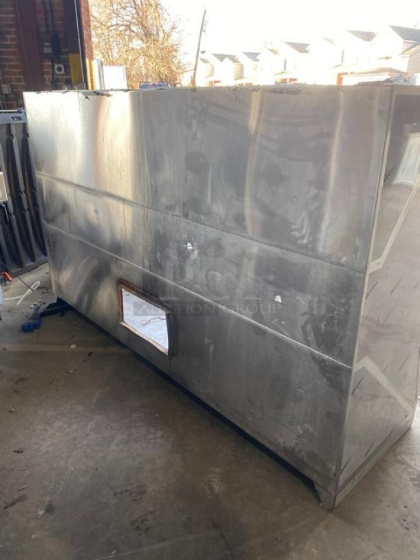 Commercial stainless steel kitchen exhaust hood in used condition, features visible vent opening, durable build, some surface wear.