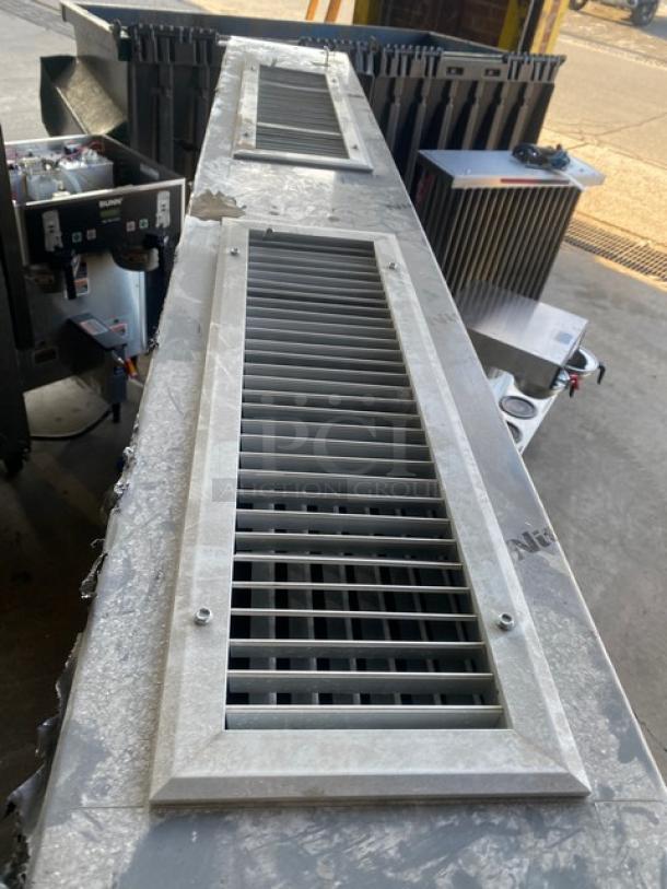 Commercial stainless steel kitchen exhaust hood with dual slatted vents, showing slight wear. Ideal for restaurant use.