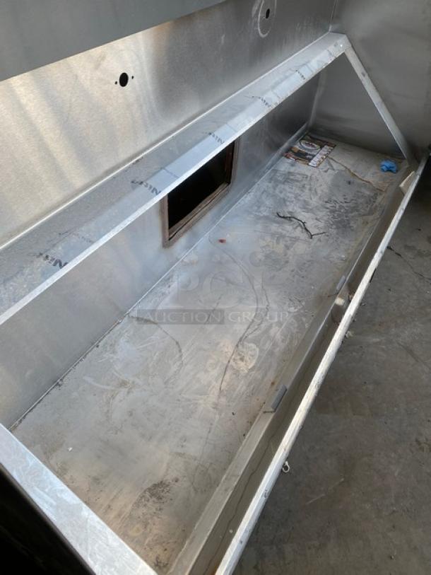 Commercial stainless steel kitchen exhaust hood, rectangular, robust build with visible vents, in used condition.
