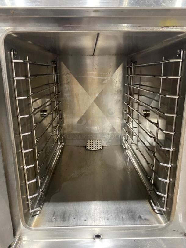 Vulcan stainless steel gas convection steamer interior, clean condition, with pan-holding equipment stand.