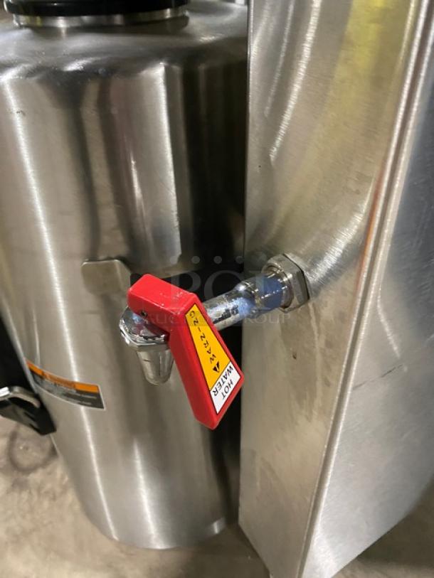 Fetco CBS62H commercial stainless steel twin coffee brewer with hot water dispenser, insulated thermal tanks, 120/208-240V, on legs.