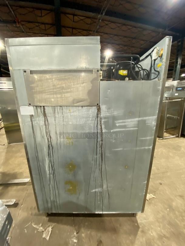 Commercial stainless steel two-door reach-in refrigerator on legs, features poly-coated wire racks, visible wear and stains.