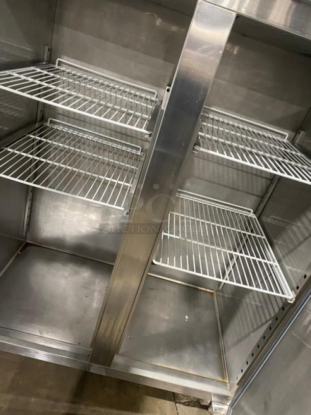 Commercial stainless steel 2-door reach-in refrigerator with poly-coated wire racks, shown on legs, in used condition.