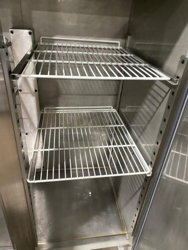 Commercial stainless steel 2-door reach-in refrigerator with poly-coated wire racks, shown on adjustable legs.