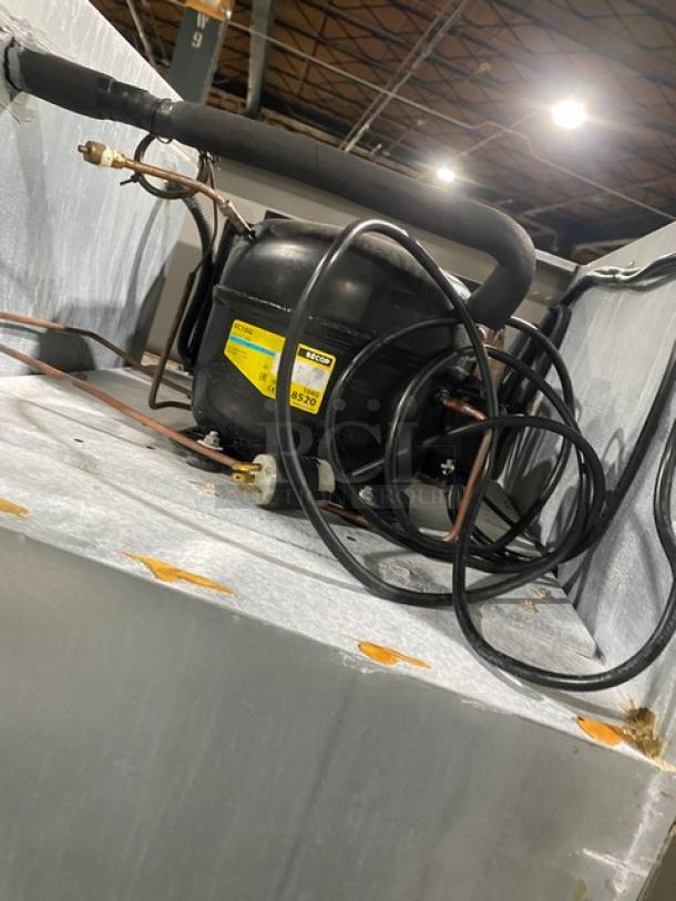 Commercial stainless steel 2-door reach-in refrigerator with poly-coated wire rack, on legs, visible compressor detail.