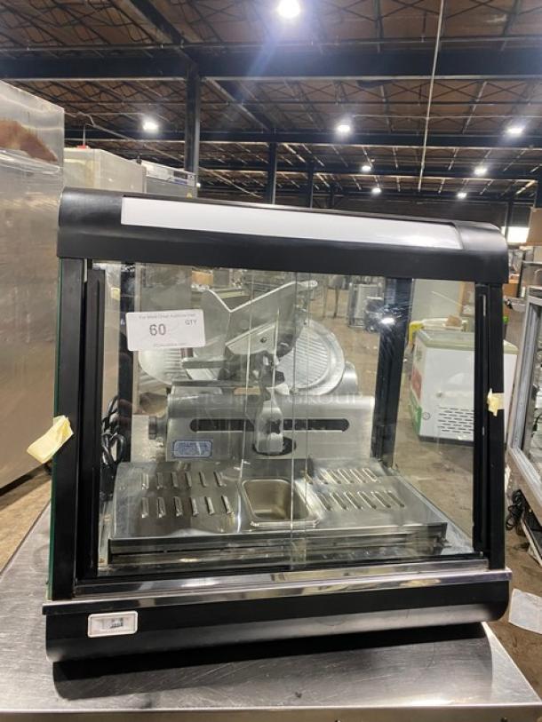 Commercial black slanted glass electric heated food display case, Model FW22, stainless interior, 110V, excellent condition.