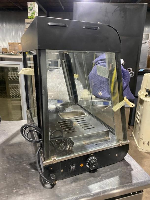 Commercial black slanted glass countertop heated food display case, model FW22, with stainless steel interior, in used condition.