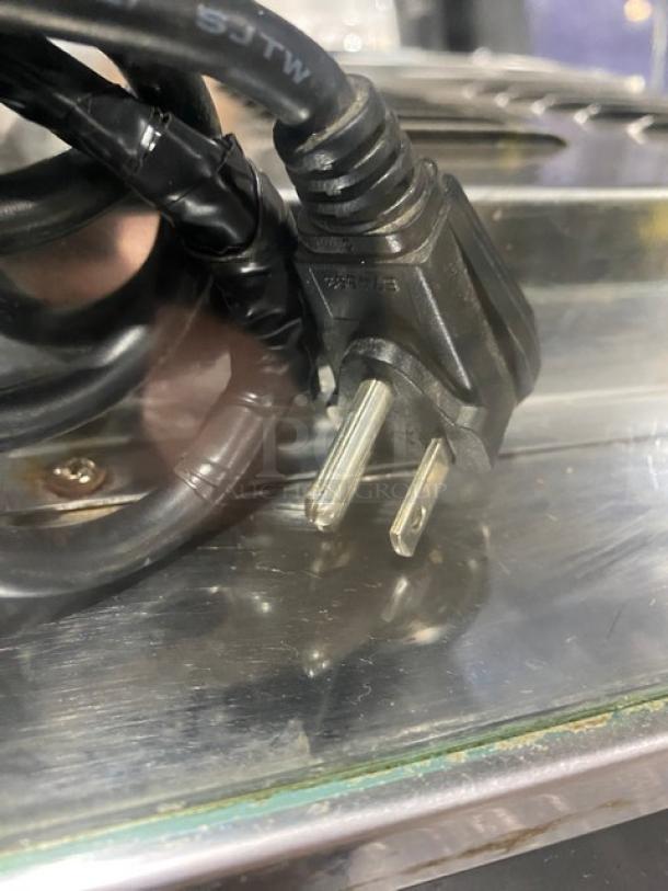 Commercial black slanted glass heated food merchandiser display case, model FW22, stainless steel interior. Equipped with 110V plug.